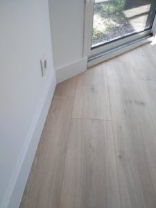 Pose de lame PVC imitation bois - Finition plinthes blanche